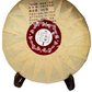 Round tea cake with a red label on a white background